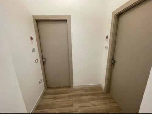 an empty hallway with two doors and a wooden floor at Marconi B&B - Holiday Home in Marconia
