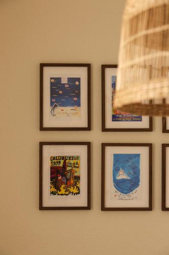 a group of framed pictures hanging on a wall at Appartement Unique! Au centre historique with 2 bedrooms and terrace in Collioure