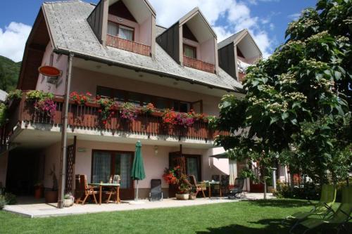 a building with a table and chairs in a yard at Apartments Kravanja in Bovec