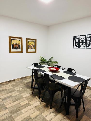 a dining room table with black chairs and a white wall at Departamento en vicente López hasta 3 personas súper comodo in Florida