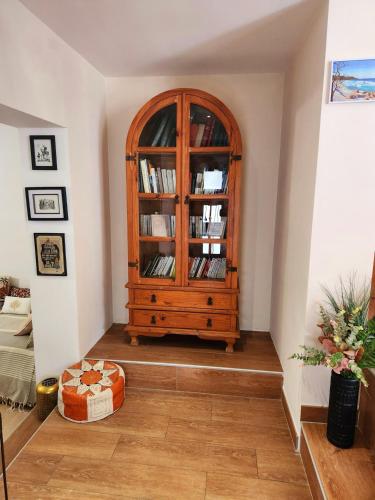 a room with a wooden cabinet with books at La Maison Sacco in LʼÎle-Rousse