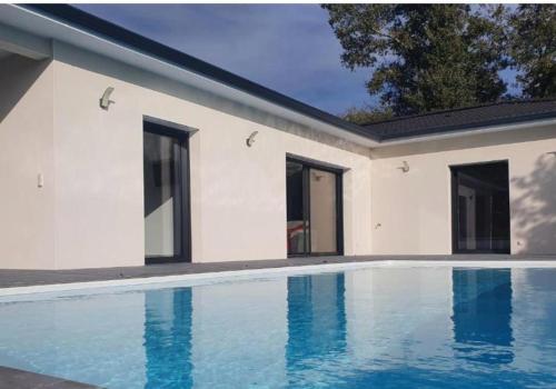 une piscine devant une maison dans l'établissement Villa les chênes, à Unzent