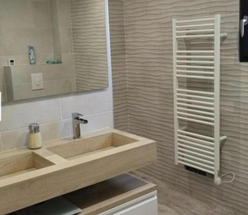 une salle de bain avec un lavabo et un miroir dans l'établissement Villa les chênes, à Unzent
