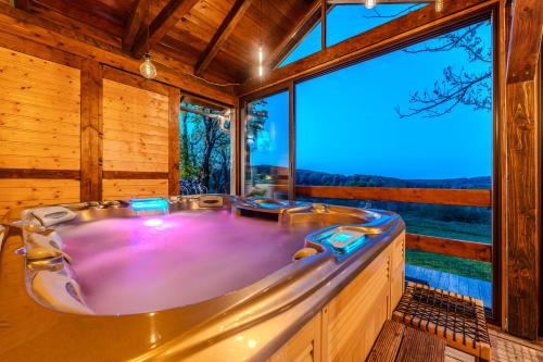 a large tub in a room with a large window at Tesla's Gastro House Plitvice in Plitvička Jezera