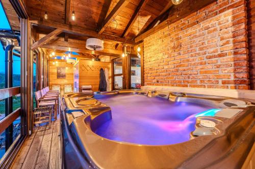 a hot tub in a room with a brick wall at Tesla's Gastro House Plitvice in Plitvička Jezera