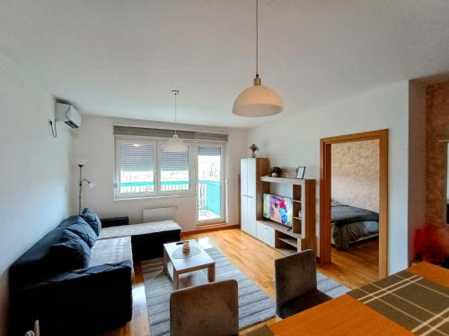 a living room with a couch and a table at MV Dreams, free parking in Novi Sad