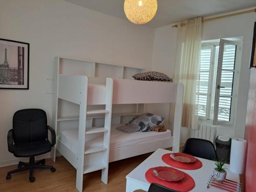 Ce lit superposé blanc se trouve dans un dortoir doté d'une table. dans l'établissement Studio confortable centre ville Poitiers, à Poitiers