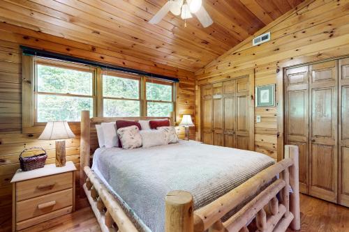 a bedroom with a bed in a log cabin at Lucilles Creekside Hideaway in Blue Ridge
