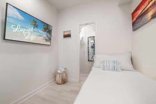 1 dormitorio blanco con 1 cama y una foto en la pared en Sea Glass 402 by Liquid Life, en Gulf Shores
