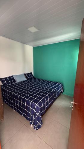 a bed in a room with blue and green walls at Casa para Rondônia Rural show in Ji-Paraná