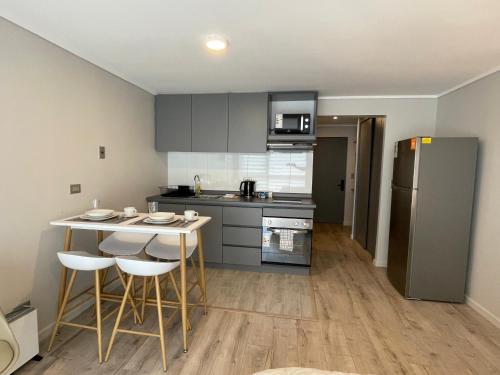 a kitchen with a table and chairs and a refrigerator at Condominio Palena in Puerto Montt
