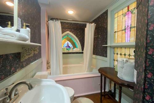 a bathroom with a sink and a stained glass window at Cricket Cottage in Eureka Springs