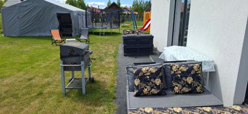 a backyard with a grill and a tent at Bursztynowa Rosa & Wypożyczalnia rowerów elektrycznych in Łeba