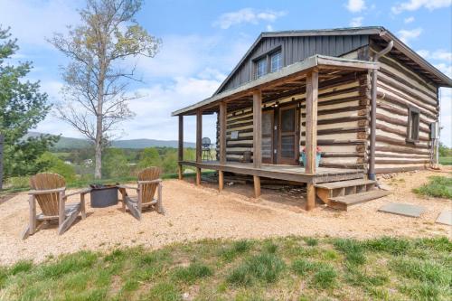 a log cabin with two chairs in front of it at Rustic Baileys Retreat Cabin Near Wineries! in Crozet