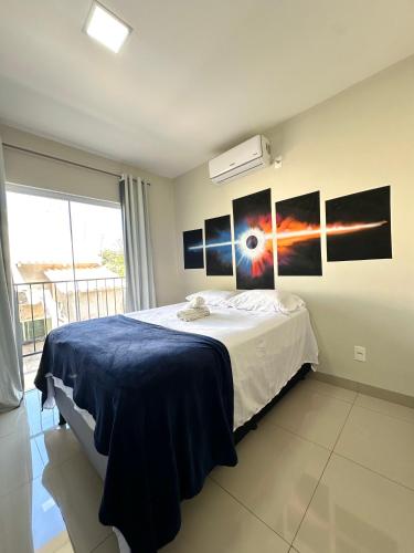 a bedroom with a bed with pictures on the wall at Flat Davisis 9 - Parada do Jalapão e Aeroporto in Palmas