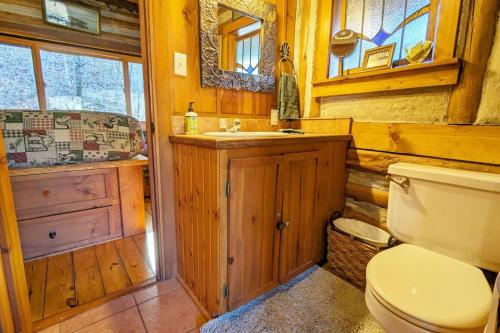 a wooden bathroom with a toilet and a sink at Coyotes Rest Lake Lucerne 8 in Eureka Springs