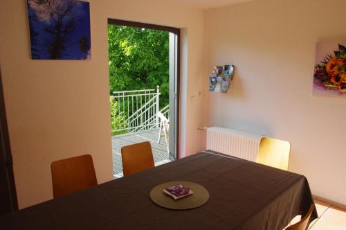a dining room with a table and a balcony at Ferienwohnung Wiesenblick in Geldern