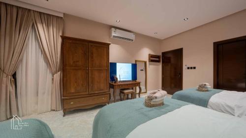 a hotel room with two beds and a television at نزل سدن in Quai