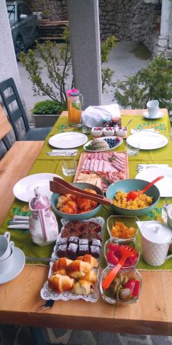 a table with many plates and bowls of food on it at TOMO 2 in Postojna
