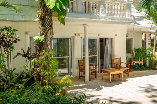 a porch of a house with two chairs and a table at Hotel Atlantis in Las Terrenas