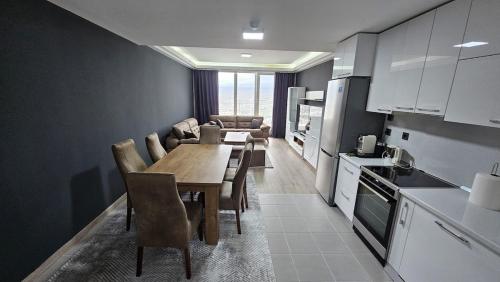 Una cocina y un comedor con mesa y sillas. en Penthouse Views-Free Pool & Spa, en Skopje