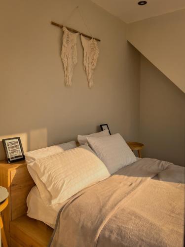 a bedroom with a bed with white sheets and towels at Moon Cabin in Simbal