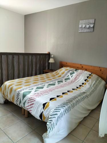 - un lit dans une chambre avec une tête de lit en bois dans l'établissement Le petit logis de Lascaux, à Montignac