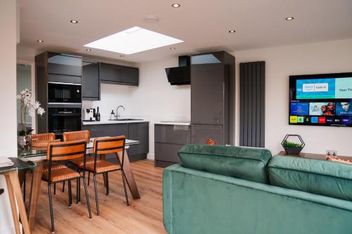 a living room with a couch and a table and chairs at Luxury Apartment nr Broadway with Private Parking! in Evesham