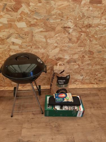 a stool and a box of magazines next to a wall at Au petit coin tranquille in Saint-Gobert