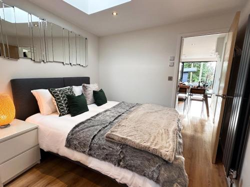a bedroom with a large bed with pillows on it at Luxury Apartment nr Broadway with Private Parking! in Evesham