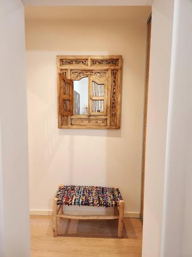 a bench in the corner of a room with a mirror at La Maison Sacco in LʼÎle-Rousse