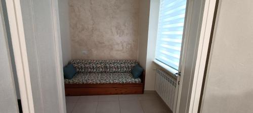a small room with a couch with a window at Dimora 99 in LʼAquila