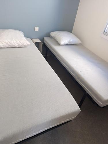 deux lits côte à côte dans une pièce dans l'établissement Mobil Home climatisé à 3 minutes de la Mer, au Grau-dʼAgde