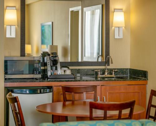 a kitchen with a table and chairs and a sink at Holiday Inn & Suites Virginia Beach - North Beach by IHG in Virginia Beach