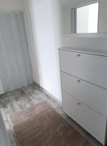 a bedroom with a white dresser and a mirror at Apartman Annie in Bihać