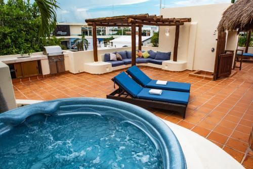 a hot tub in a backyard with a couch and chairs at Porto Playa Condo Hotel and Beach Club in Playa del Carmen