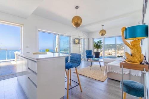 a kitchen and living room with a view of the ocean at Pearl Sesimbra in Sesimbra