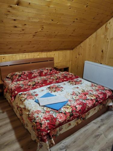 a bed with a book on it in a room at Casute ,, la dani" in Corbu