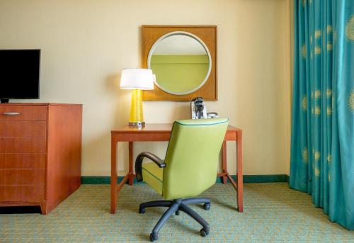 a room with a desk and a chair and a mirror at Holiday Inn & Suites Virginia Beach - North Beach by IHG in Virginia Beach