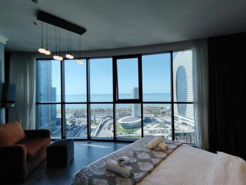 a bedroom with a bed and a large window at Grand Marina Apartments Batumi in Batumi