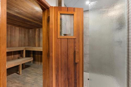 una puerta de madera que da a una sauna en Chalet Genteman 23 pers Piscine spa et sauna, en Sainte-Agathe-des-Monts