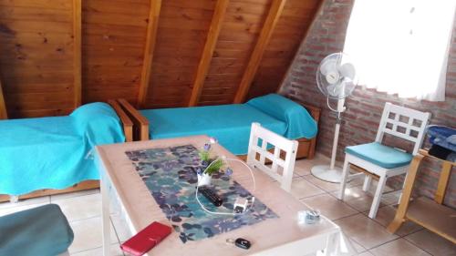 a room with a bed and a table and chairs at Cabañas Jazmines del Lago in San Roque