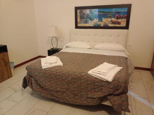 a bedroom with a bed with two towels on it at Villa Giove Rooms in Prato
