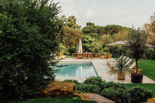 - une piscine dans une cour avec une table et un parasol dans l'établissement Villa in Luxury Estate, Mougins, à Mougins
