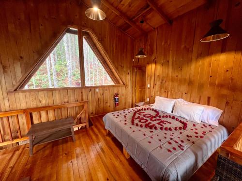 ein Schlafzimmer mit einem Bett in einem Holzzimmer in der Unterkunft Nido de Madera in San Mateo Río Hondo