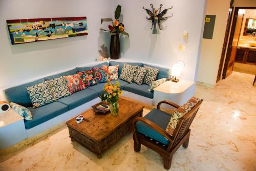 a living room with a blue couch and a table at Porto Playa Condo Hotel and Beach Club in Playa del Carmen