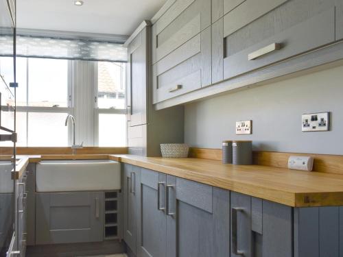a kitchen with blue cabinets and a sink at The Rocket in Flamborough