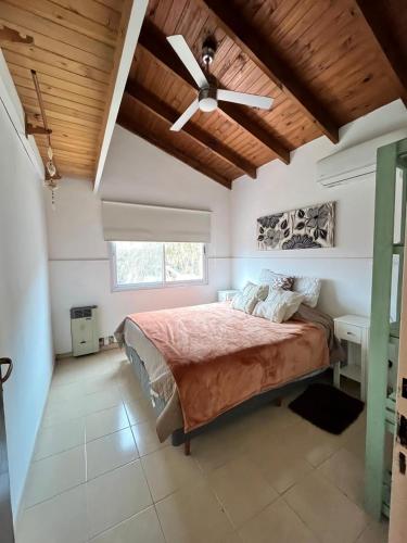 a bedroom with a bed and a ceiling fan at La Casita in San Antonio de Areco