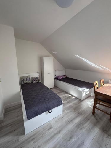 a attic bedroom with two beds and a table at Agroturystyka u Miłosza in Górowo-Trzęski