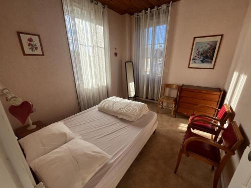 une chambre avec un lit et une chaise dedans dans l'établissement Aux Roses, à Saint-Honoré-les-Bains